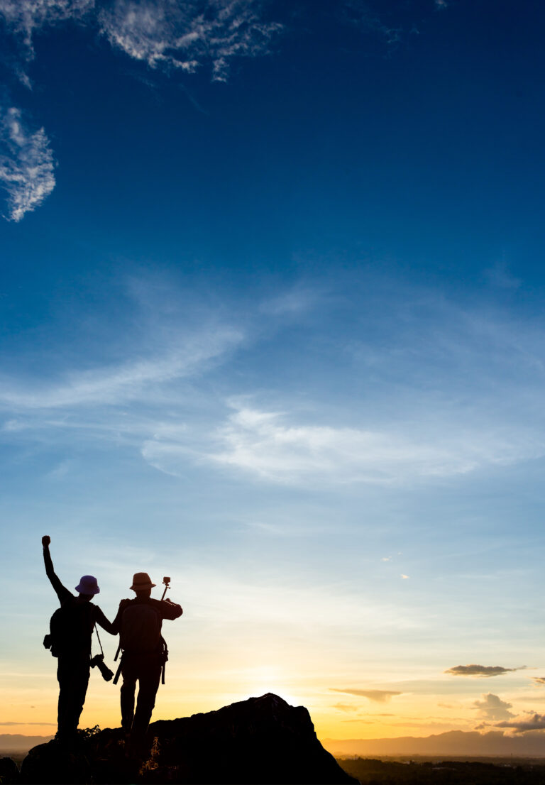 Silhouette of man hold up hands on the peak of mountain,success concept